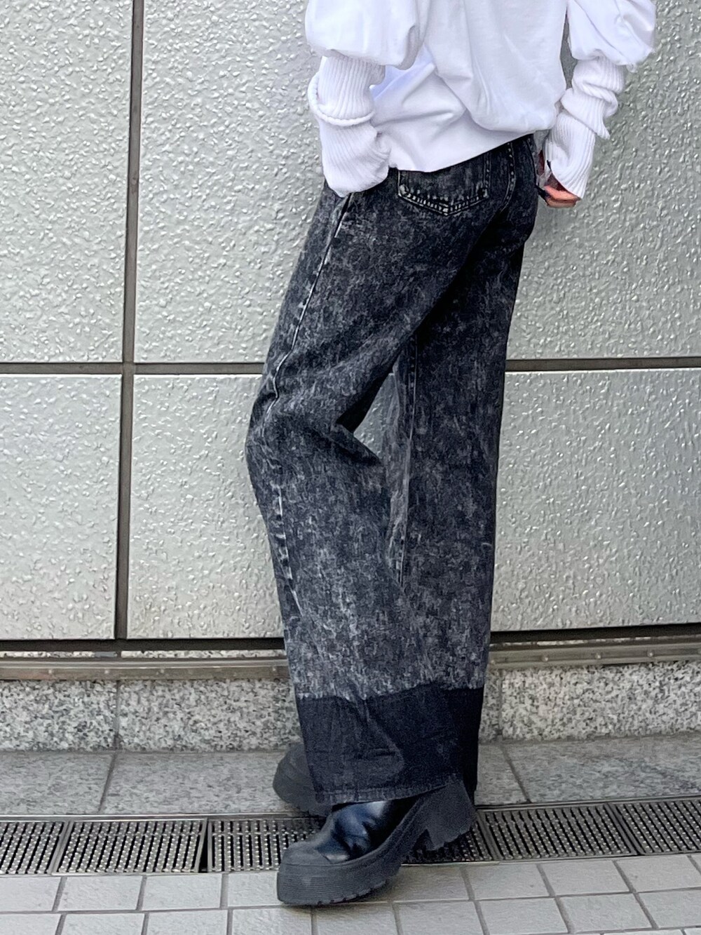 ホワイト系のスウェット、ブラック系のデニムパンツ、ブラック系のブーツを着用したレディースの秋コーディネートの7枚目の写真