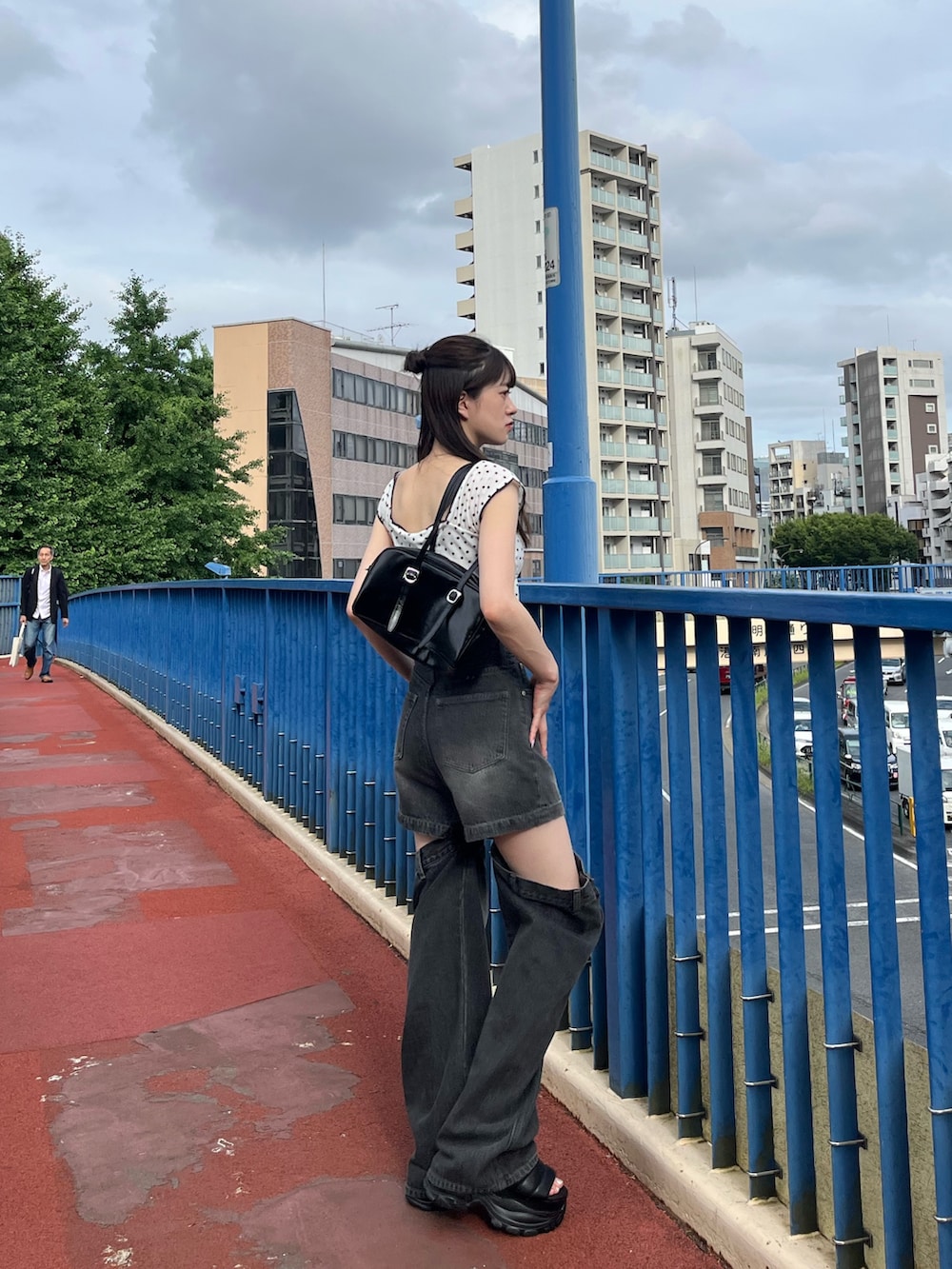 ホワイト系のタンクトップ、ブラック系のデニムパンツ、ブラック系のサンダルを着用したレディースの夏コーディネートの4枚目の写真