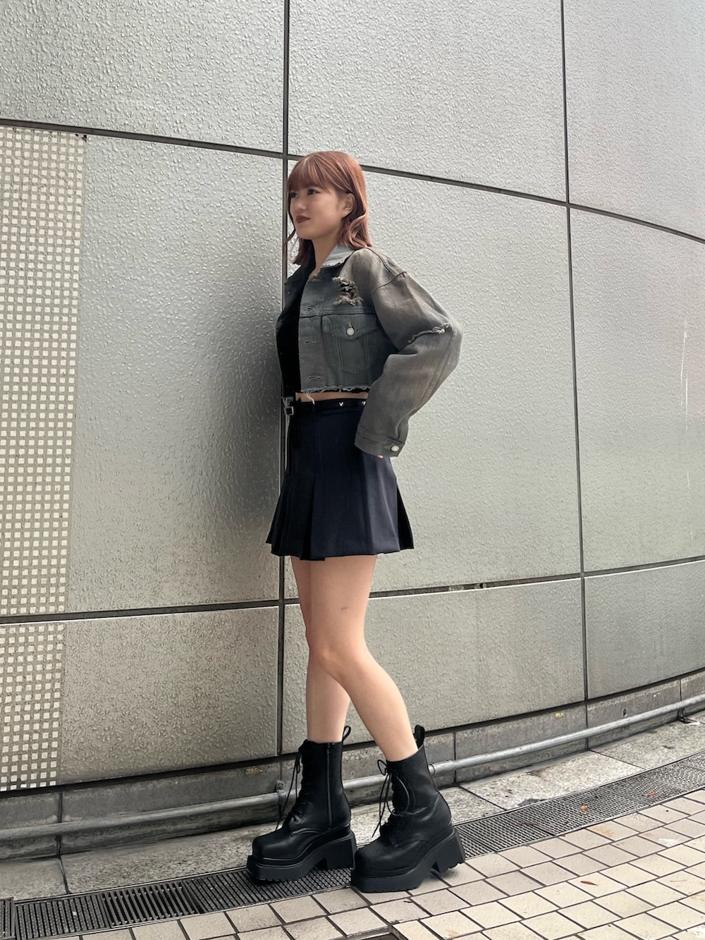 ブラック系のニット/セーター、グレー系のスカート、ブラック系のブーツを着用したレディースの冬コーディネートの2枚目の写真