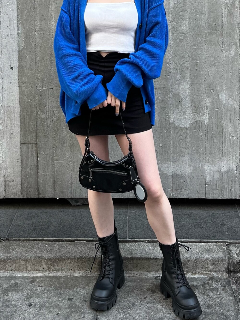 ブラック系のハンドバッグ、ブラック系のブーツ、ホワイト系のキャミソールを着用したレディースの春コーディネートの7枚目の写真