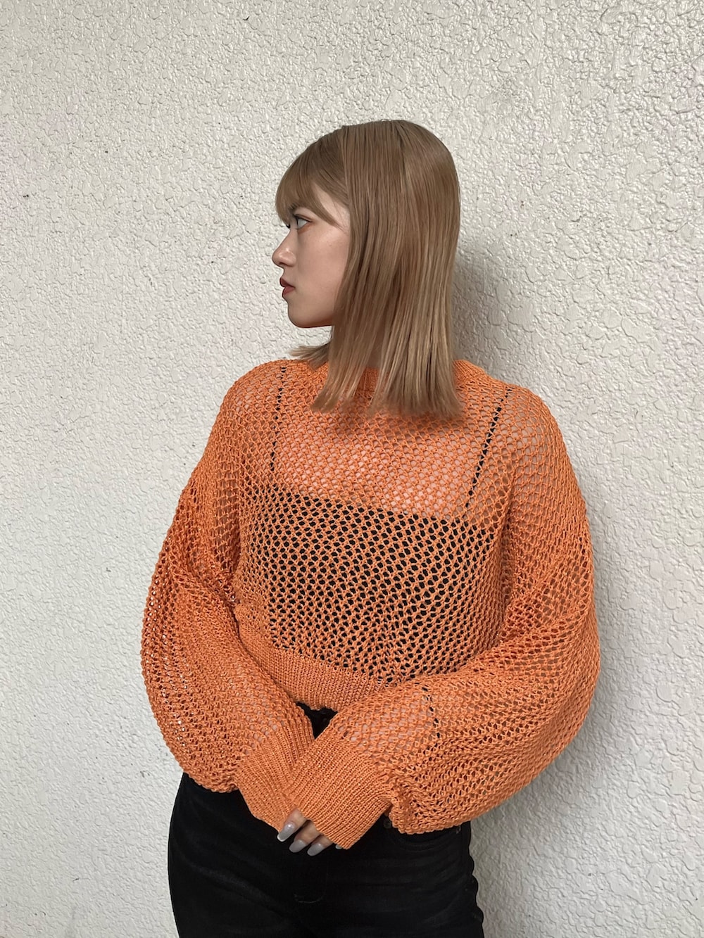 ブラック系のキャミソール、オレンジ系のニット/セーター、ブラック系のサンダルを着用したレディースの春コーディネートの5枚目の写真