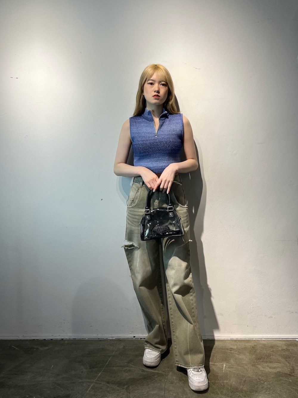 ベージュ系のデニムパンツ、その他のハンドバッグ、ブルー系のタンクトップを着用したレディースの春コーディネートの2枚目の写真