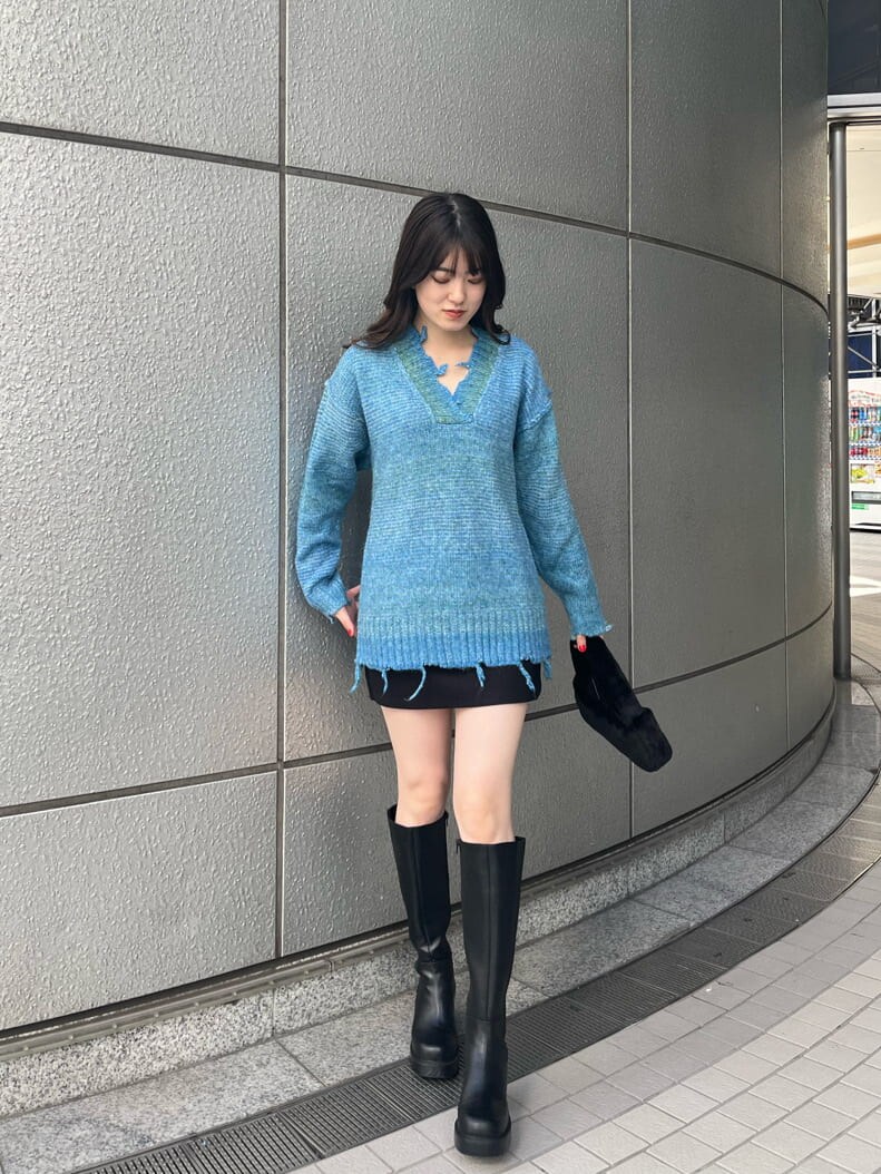 ブラック系のブーツ、ブラック系のスカート、ブルー系のニット/セーターを着用したレディースの秋コーディネートの2枚目の写真