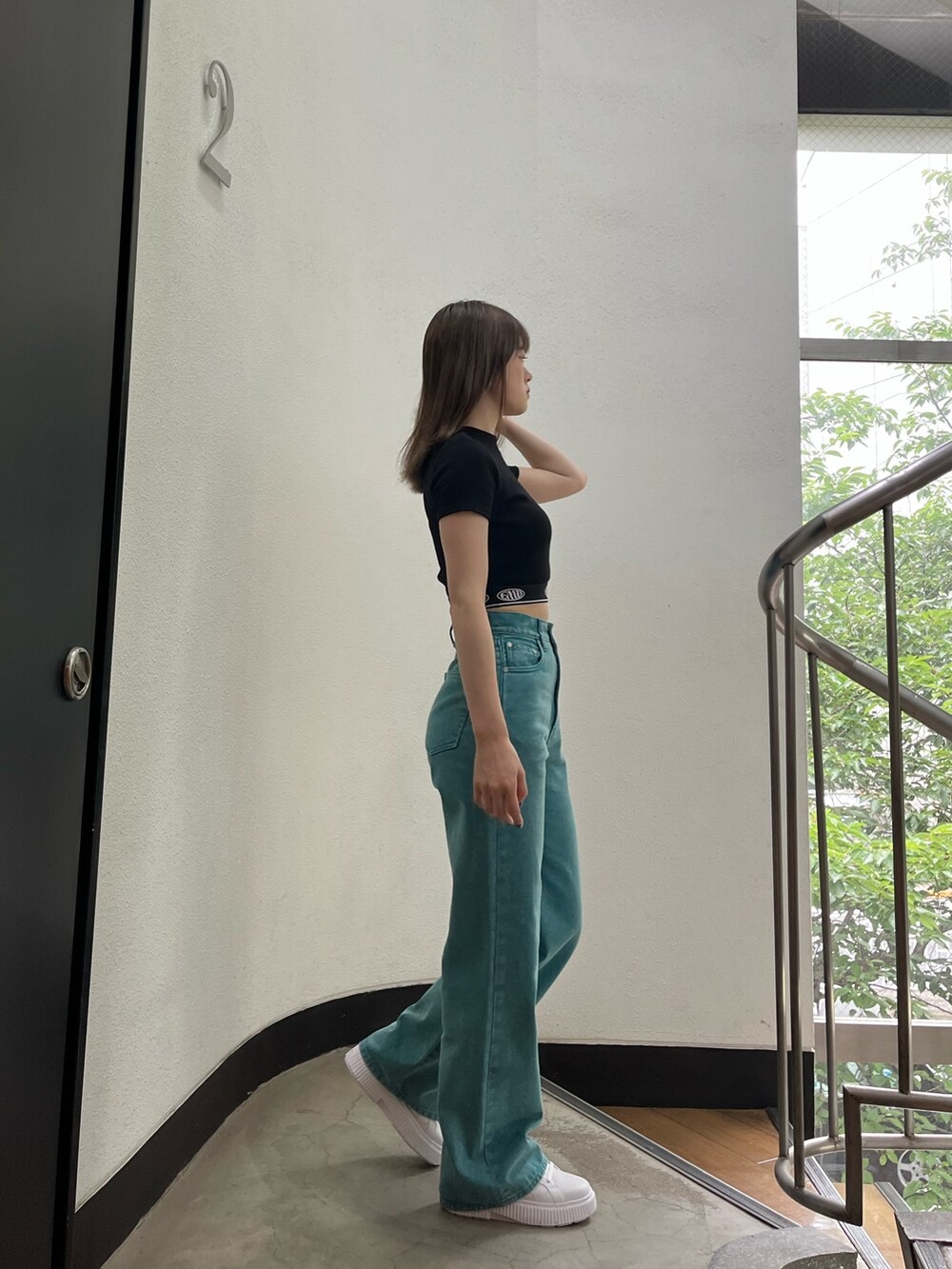 グリーン系のデニムパンツ、ブラック系のTシャツ/カットソー、ホワイト系のスニーカーを着用したレディースの夏コーディネートの4枚目の写真