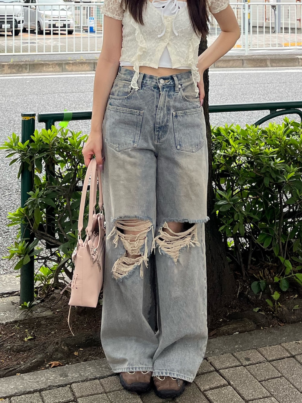 ブルー系のデニムパンツ、ブラウン系のスニーカー、ピンク系のショルダーバッグを着用したレディースの夏コーディネートの5枚目の写真
