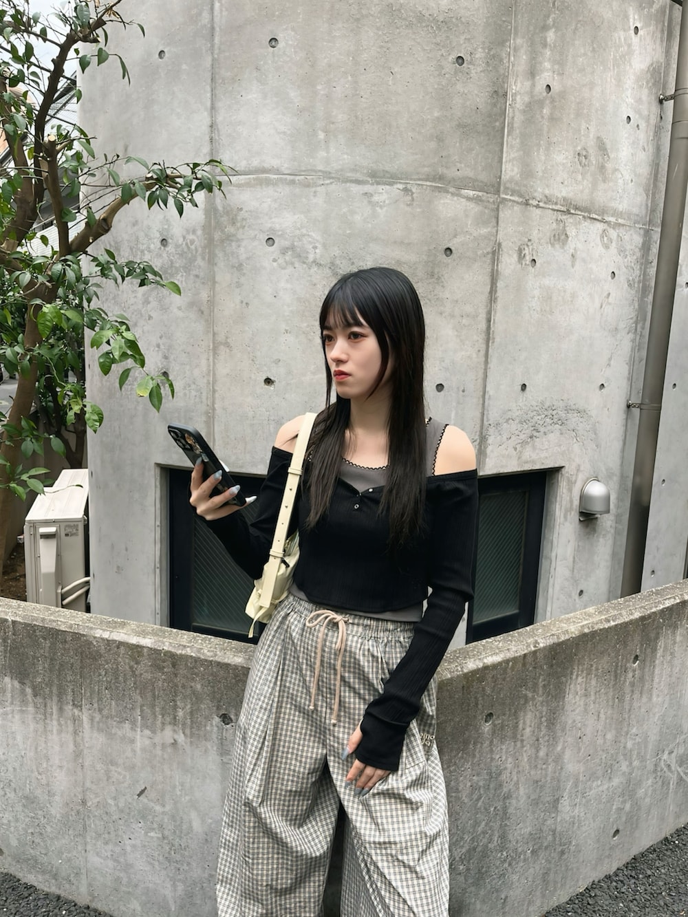 ブラック系のTシャツ/カットソー、ベージュ系のその他パンツ、ブラック系のスニーカーを着用したレディースの春コーディネートの2枚目の写真