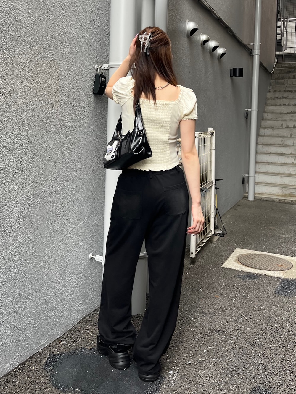 ホワイト系のTシャツ/カットソー、ブラック系のスウェットパンツ、ブラック系のハンドバッグを着用したレディースの夏コーディネートの3枚目の写真