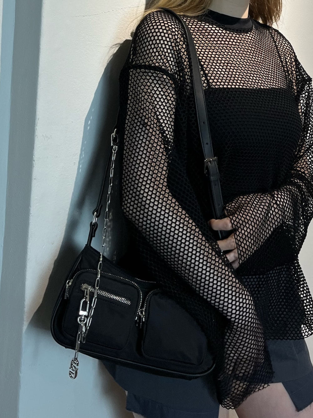 ブラック系のブーツ、ブラック系のキャミソール、ブラック系のハンドバッグを着用したレディースの夏コーディネートの7枚目の写真