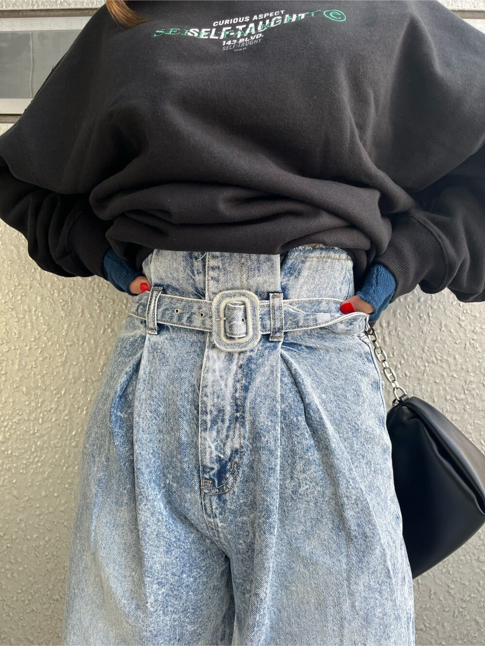 その他のパンプス、ブルー系のデニムパンツ、ブラック系のスウェットを着用したレディースの秋コーディネートの7枚目の写真