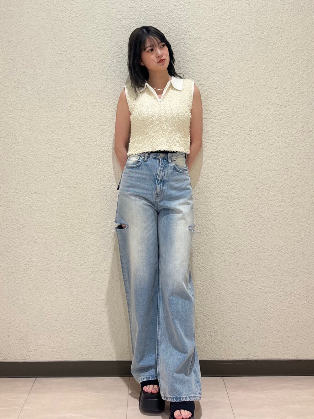 ブルー系のデニムパンツ、ブラック系のサンダル、ホワイト系のタンクトップを着用したレディースの夏コーディネートの2枚目の写真