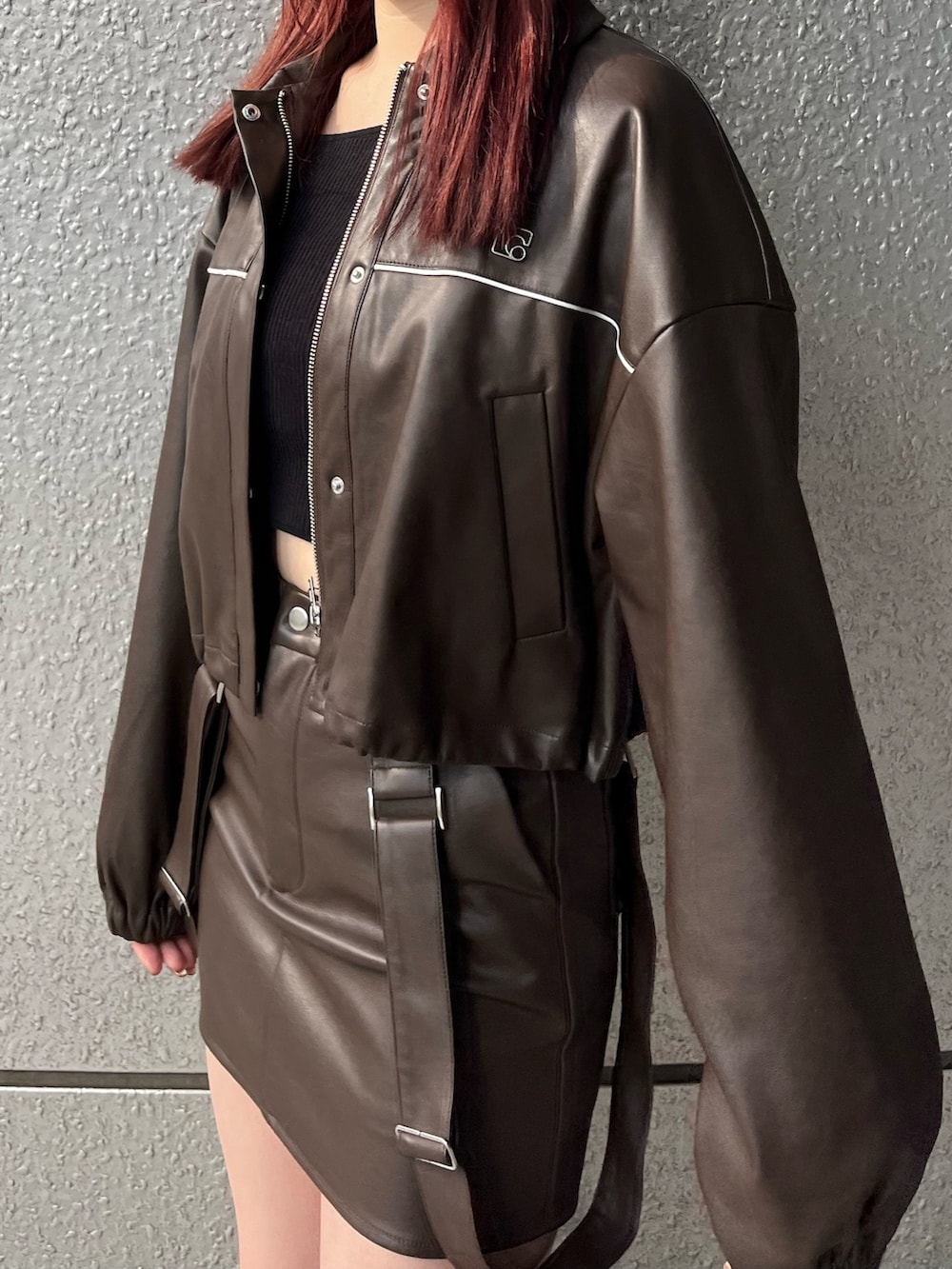 ブラウン系のスカート、ブラック系のニット/セーター、ブラウン系のブルゾンを着用したレディースの冬コーディネートの7枚目の写真