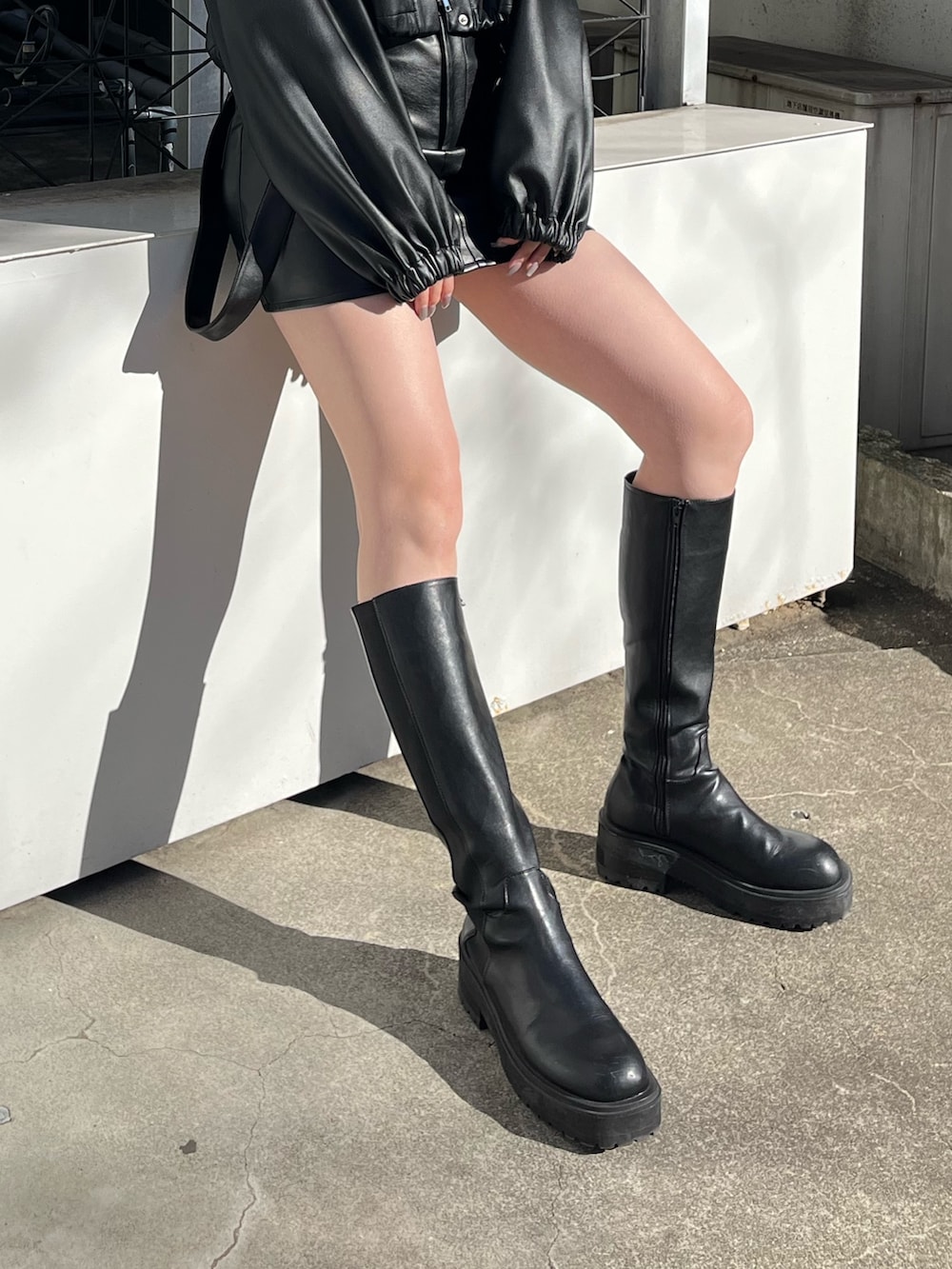 ホワイト系のニット/セーター、ブラック系のブーツ、ブラック系のブルゾンを着用したレディースの冬コーディネートの6枚目の写真