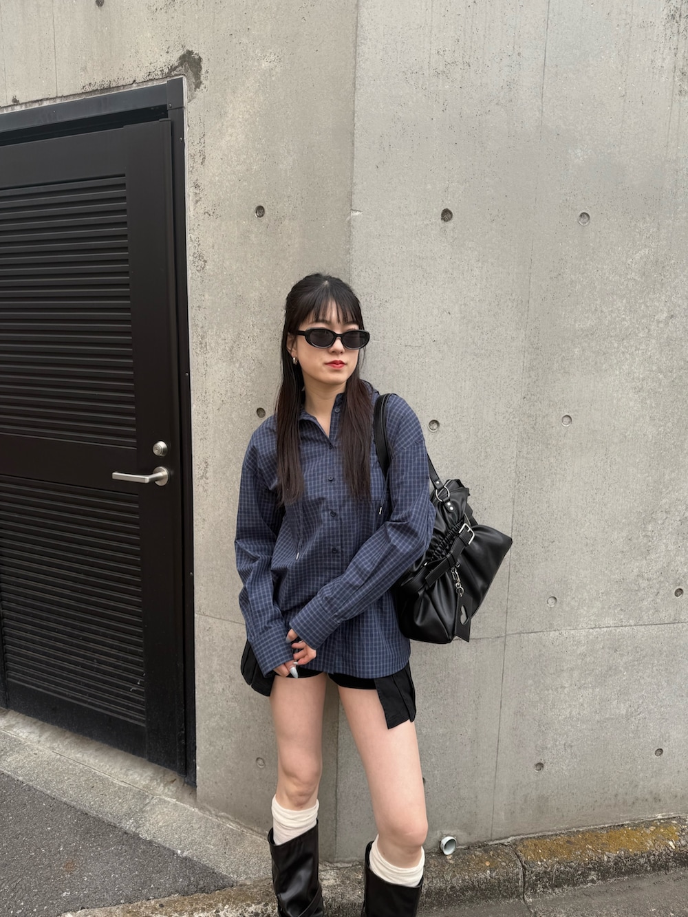 ブラック系のブーツ、ブルー系のシャツ/ブラウス、ブラック系のスカートを着用したレディースの春コーディネートの4枚目の写真