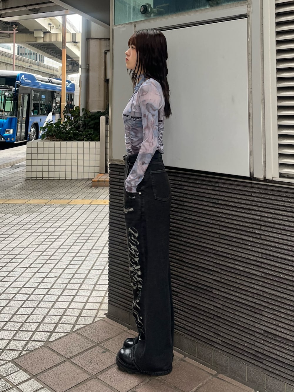 ブラック系のデニムパンツ、ブルー系のTシャツ/カットソー、ブラック系のブーツを着用したレディースの春コーディネートの2枚目の写真