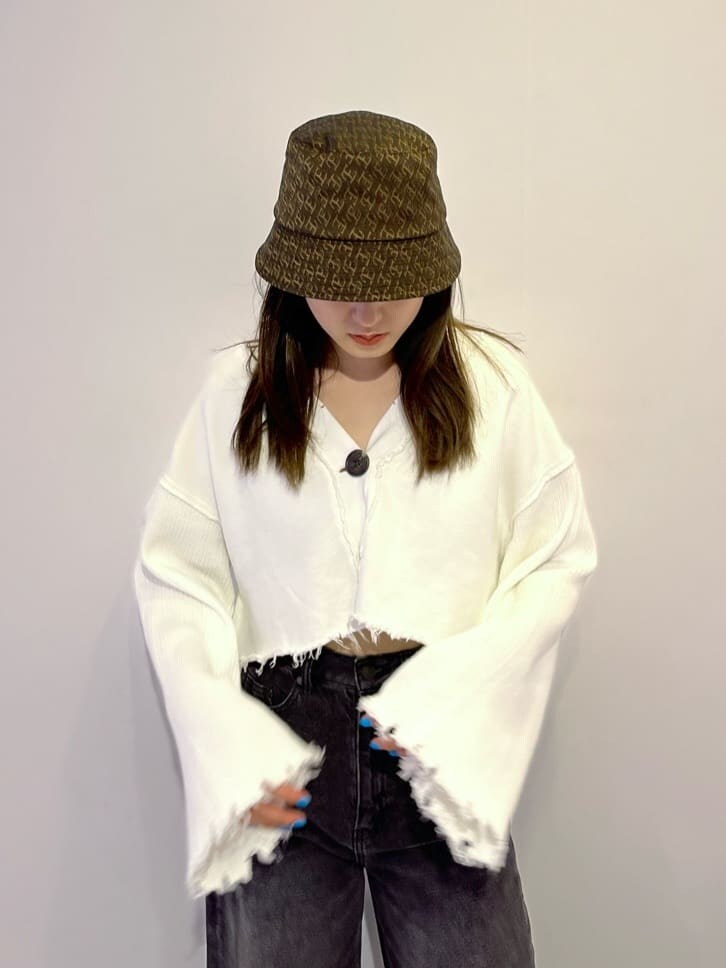 ブラウン系のブーツ、ホワイト系のカーディガン/ボレロ、グレー系のデニムパンツを着用したレディースの秋コーディネートの6枚目の写真