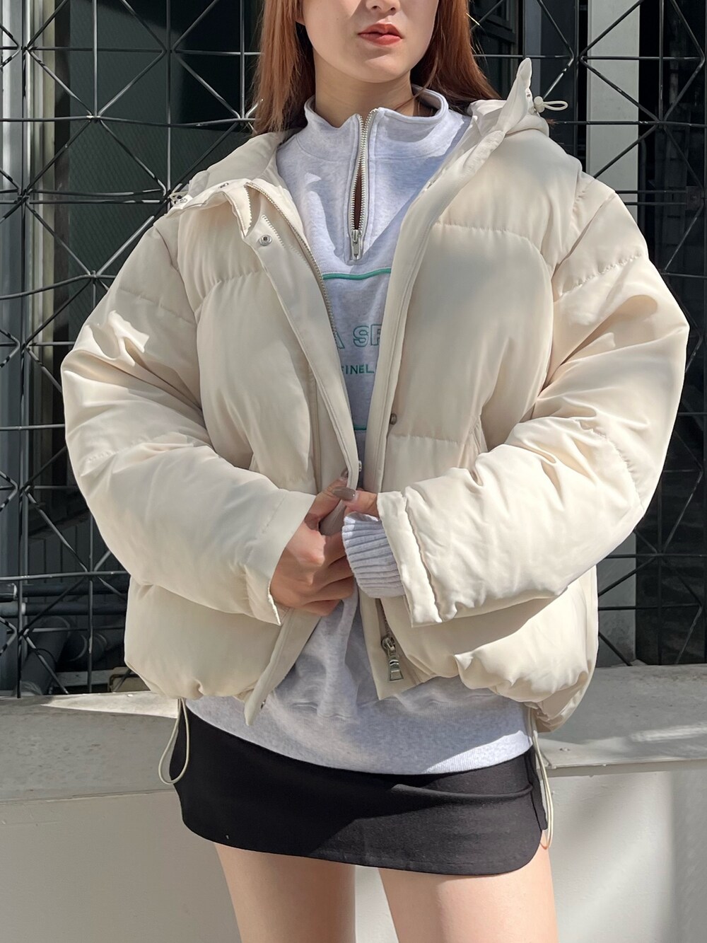 グレー系のスウェット、ホワイト系のブルゾン、ブラック系のスカートを着用したレディースの秋コーディネートの4枚目の写真