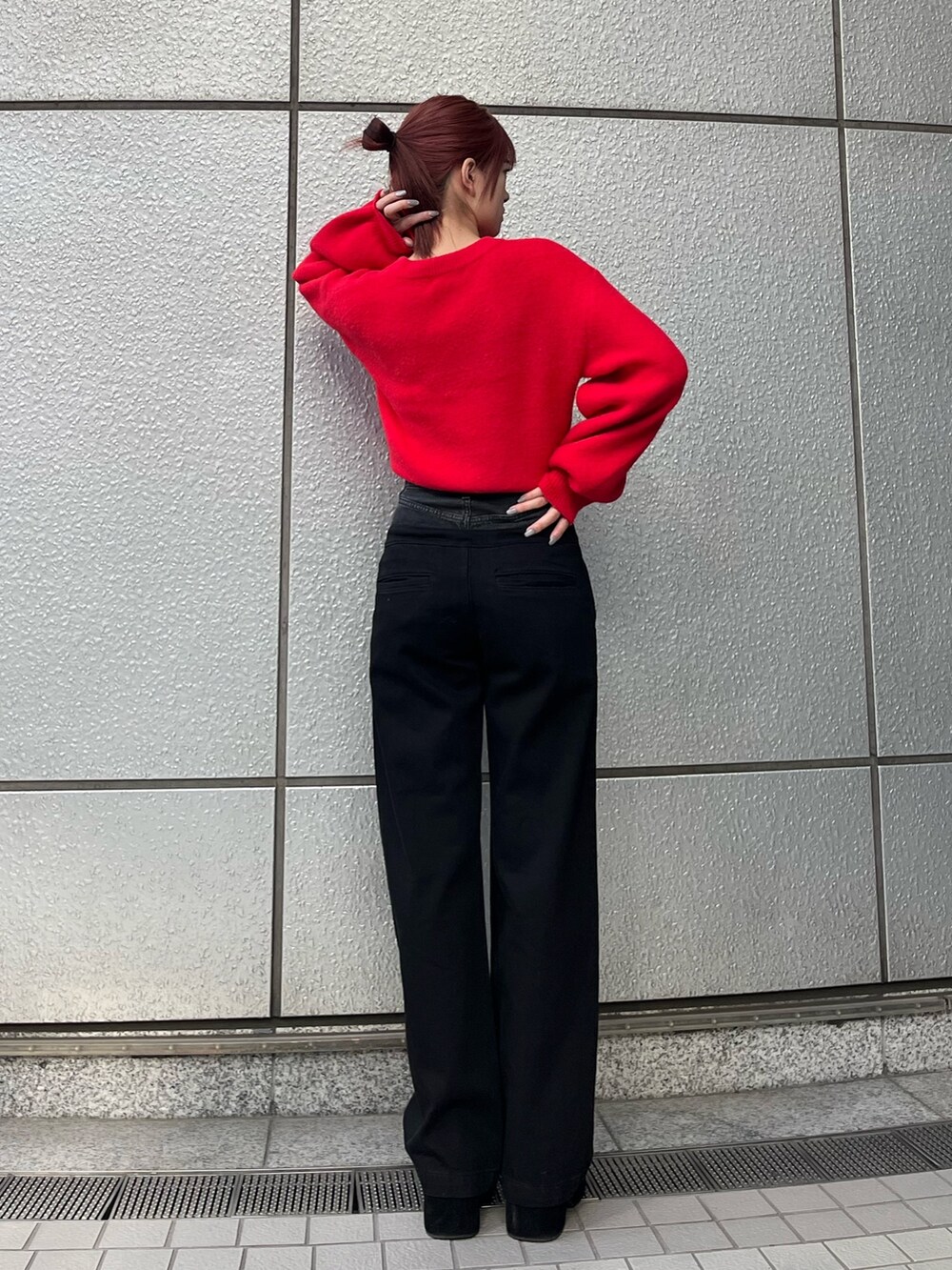 レッド系のニット/セーター、ブラック系のデニムパンツ、ブラック系のブーツを着用したレディースの冬コーディネートの5枚目の写真