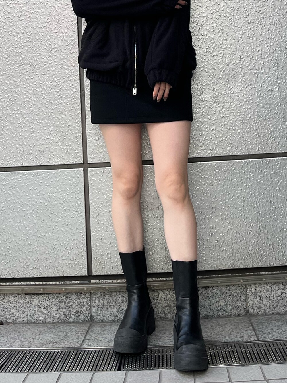ブラック系のスカート、ブラック系のブーツ、ブラック系のブルゾンを着用したレディースの秋コーディネートの5枚目の写真