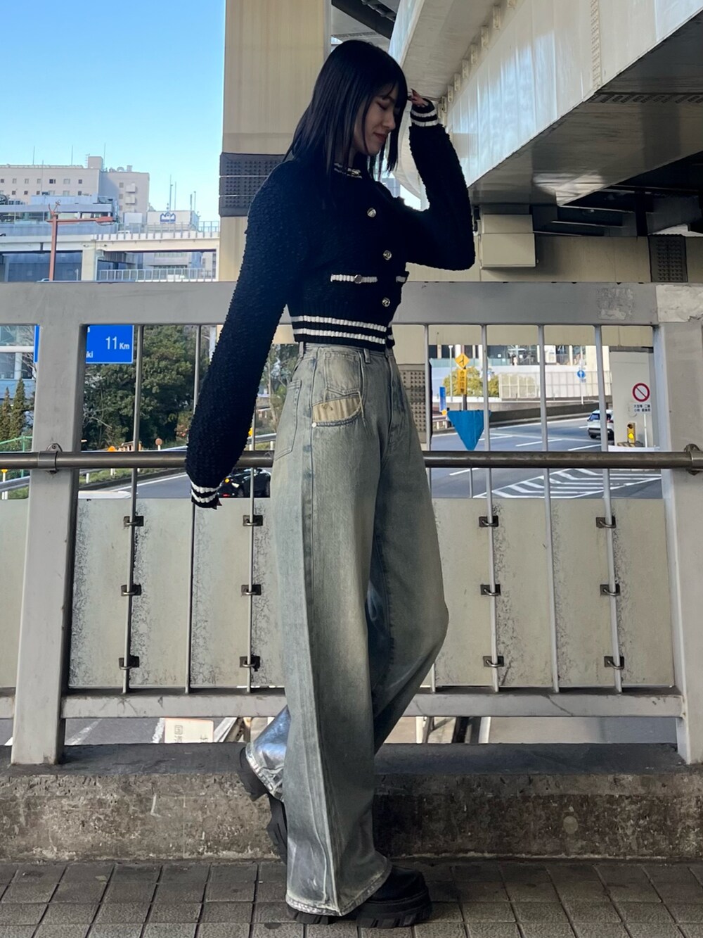 ブルー系のデニムパンツ、ブラック系のブーツ、ブラック系のカーディガン/ボレロを着用したレディースの冬コーディネートの4枚目の写真