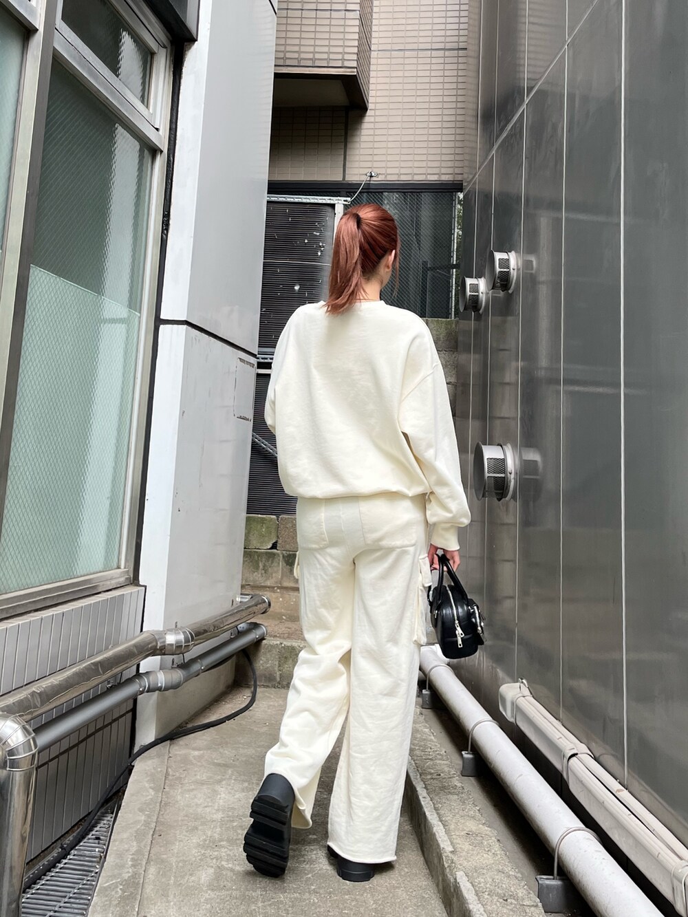 ホワイト系のTシャツ/カットソー、ホワイト系のその他パンツ、ブラック系のブーツを着用したレディースの秋コーディネートの4枚目の写真