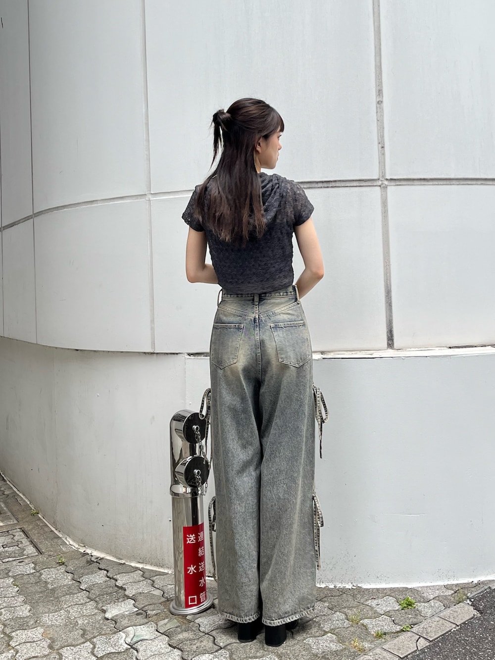 ブルー系のデニムパンツ、ブラック系のサンダル、グレー系のTシャツ/カットソーを着用したレディースの夏コーディネートの3枚目の写真