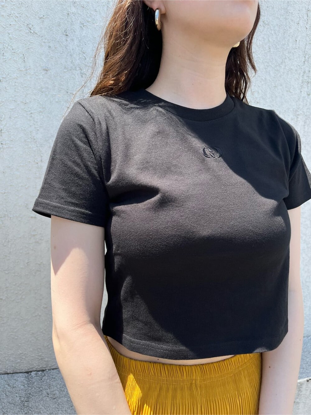 イエロー系のその他パンツ、ブラック系のTシャツ/カットソー、ブラック系のサンダルを着用したレディースの夏コーディネートの5枚目の写真