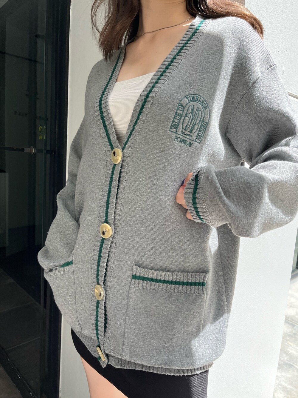 グレー系のカーディガン/ボレロ、ブラック系のスカート、ブラック系のブーツを着用したレディースの夏コーディネートの7枚目の写真