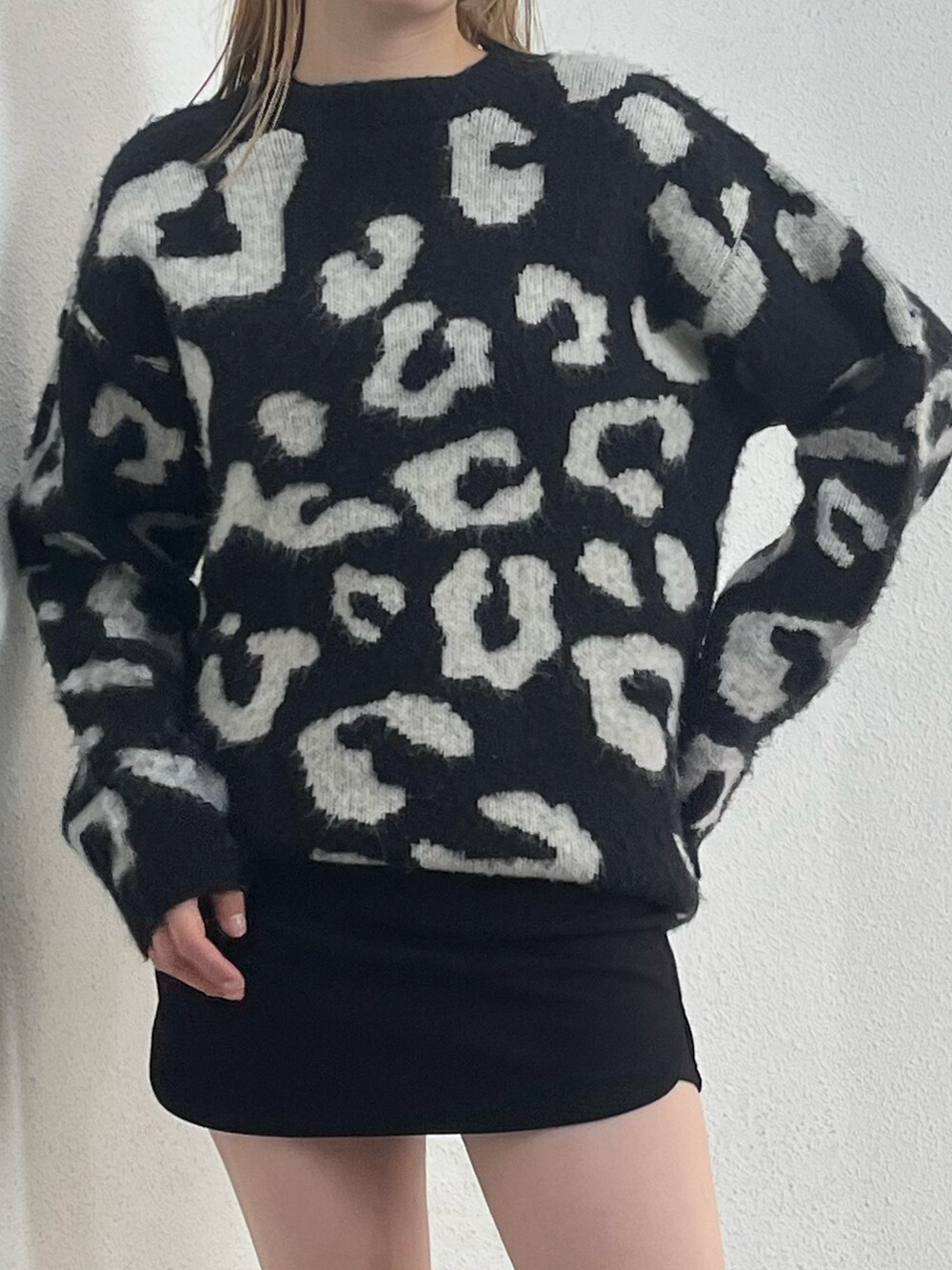 ブラウン系のブーツ、ブラック系のスカート、ブラック系のニット/セーターを着用したレディースの冬コーディネートの7枚目の写真