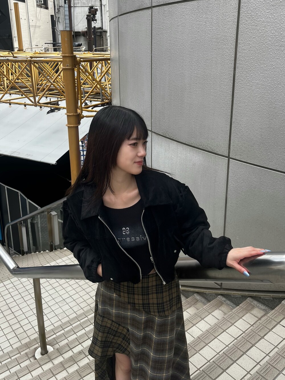 グリーン系のスカート、ブラック系のTシャツ/カットソー、ブラック系のブルゾンを着用したレディースの秋コーディネートの4枚目の写真