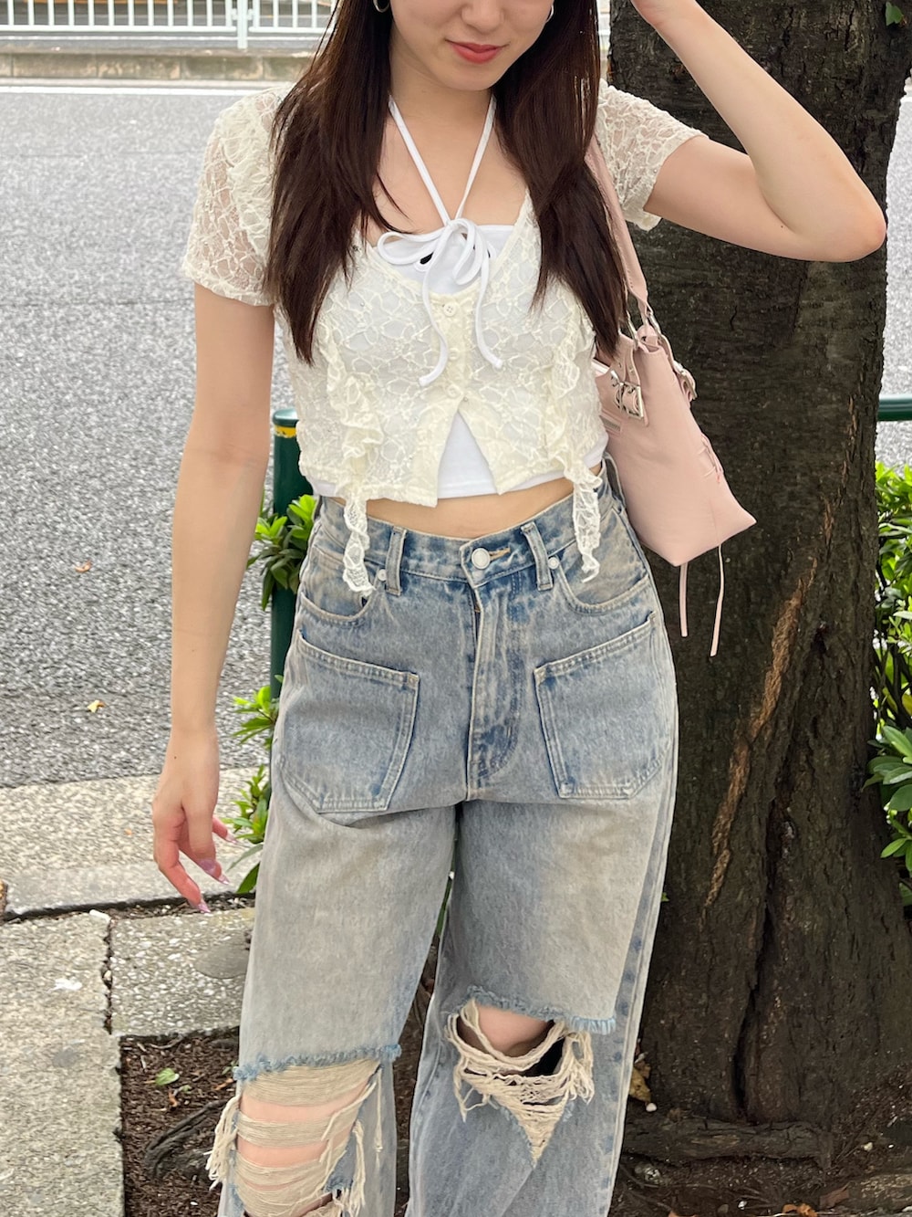 ブルー系のデニムパンツ、ブラウン系のスニーカー、ピンク系のショルダーバッグを着用したレディースの夏コーディネートの4枚目の写真