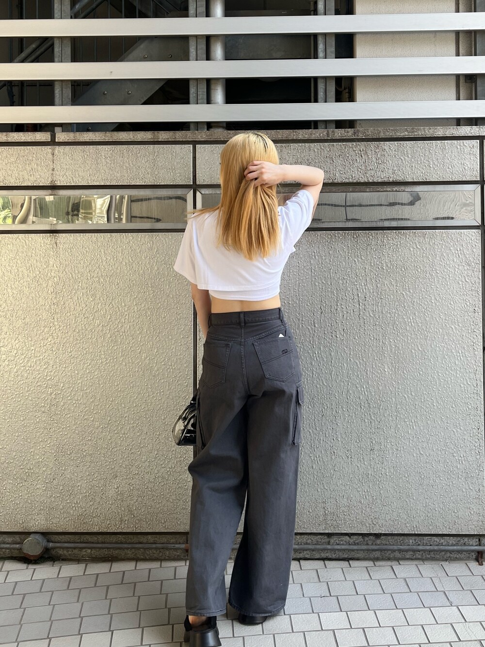 ホワイト系のTシャツ/カットソー、ブラック系のサンダル、ブラック系のデニムパンツを着用したレディースの春コーディネートの5枚目の写真