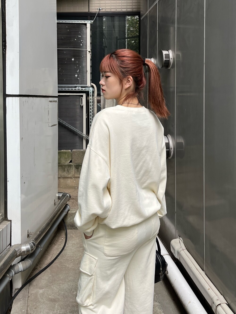 ホワイト系のTシャツ/カットソー、ホワイト系のその他パンツ、ブラック系のブーツを着用したレディースの秋コーディネートの6枚目の写真