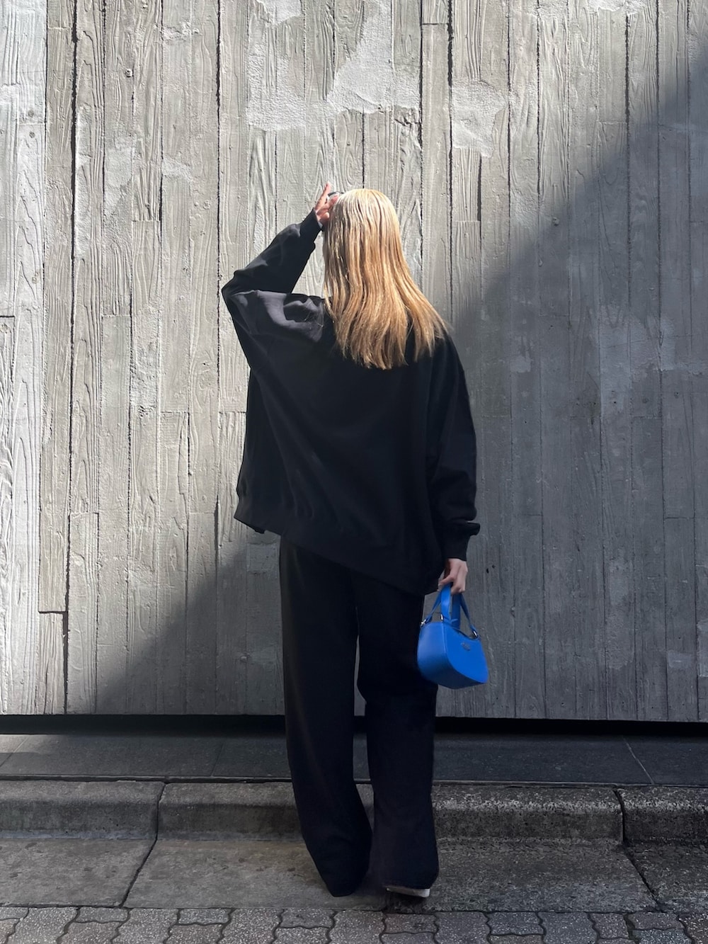 ホワイト系のキャミソール、ブラック系のカーディガン/ボレロ、ブルー系のハンドバッグを着用したレディースの春コーディネートの4枚目の写真