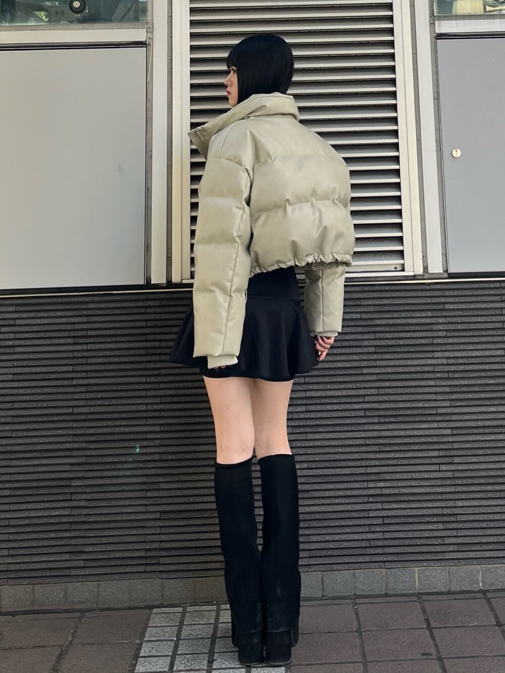 ブラック系のスカート、ブラック系のブーツ、ブラック系のニット/セーターを着用したレディースの冬コーディネートの4枚目の写真