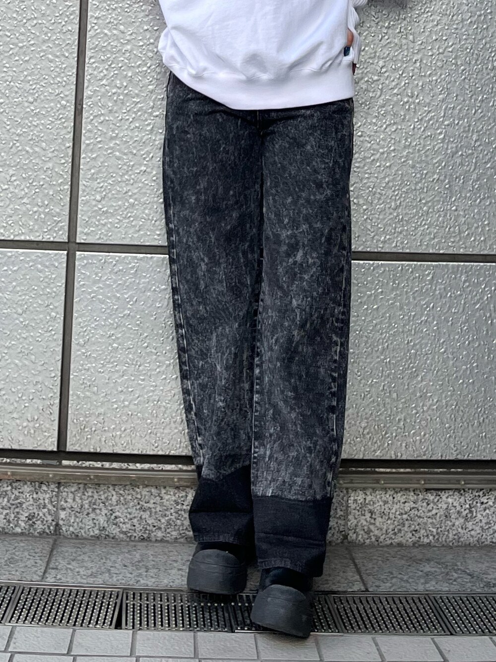 ホワイト系のスウェット、ブラック系のデニムパンツ、ブラック系のブーツを着用したレディースの秋コーディネートの6枚目の写真