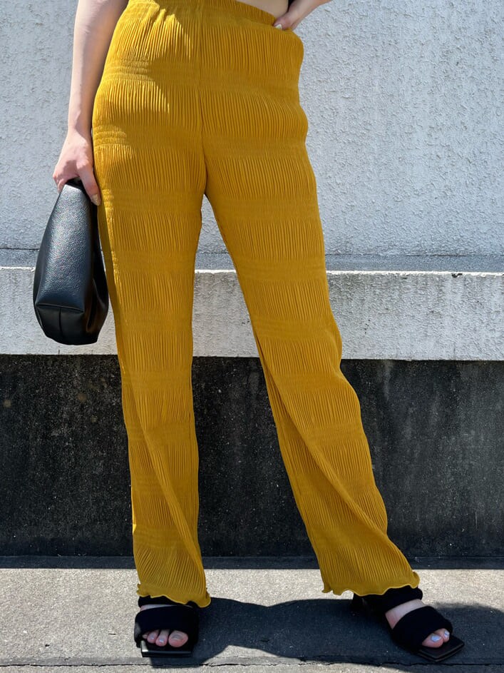 イエロー系のその他パンツ、ブラック系のTシャツ/カットソー、ブラック系のサンダルを着用したレディースの夏コーディネートの6枚目の写真