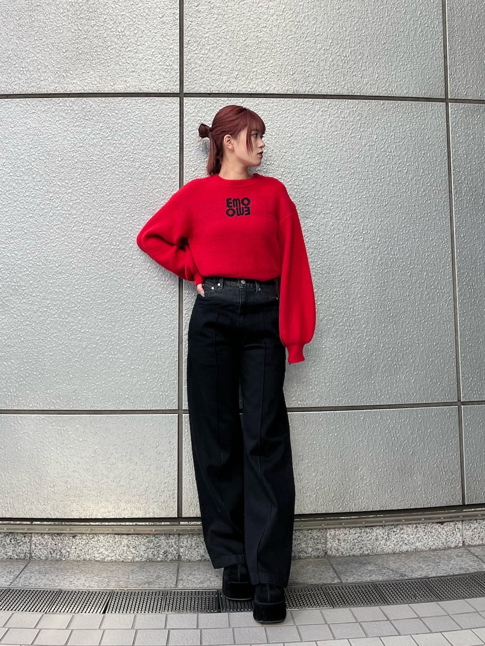 レッド系のニット/セーター、ブラック系のデニムパンツ、ブラック系のブーツを着用したレディースの冬コーディネートの2枚目の写真