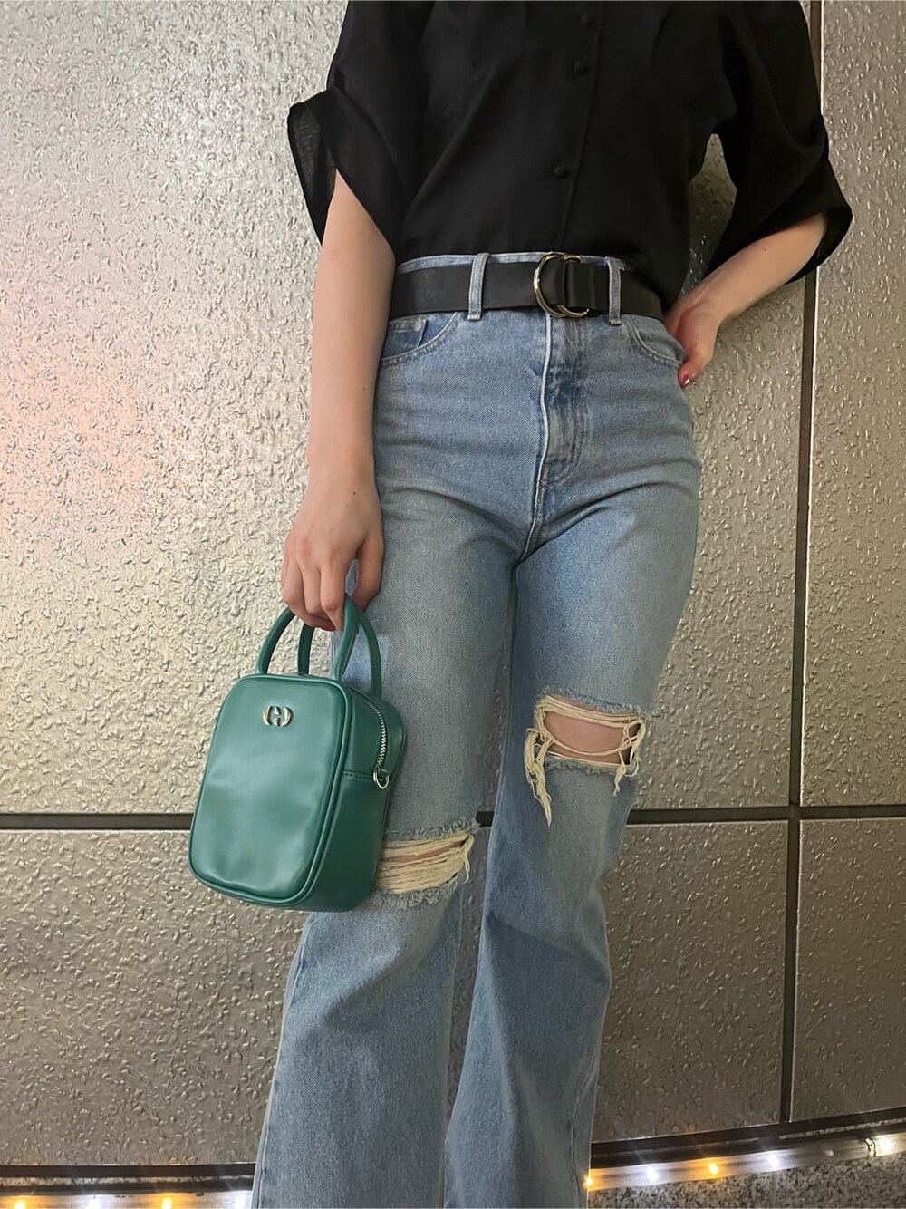 ブルー系のショルダーバッグ、ブラック系のサンダル、ブルー系のデニムパンツを着用したレディースの春コーディネートの5枚目の写真