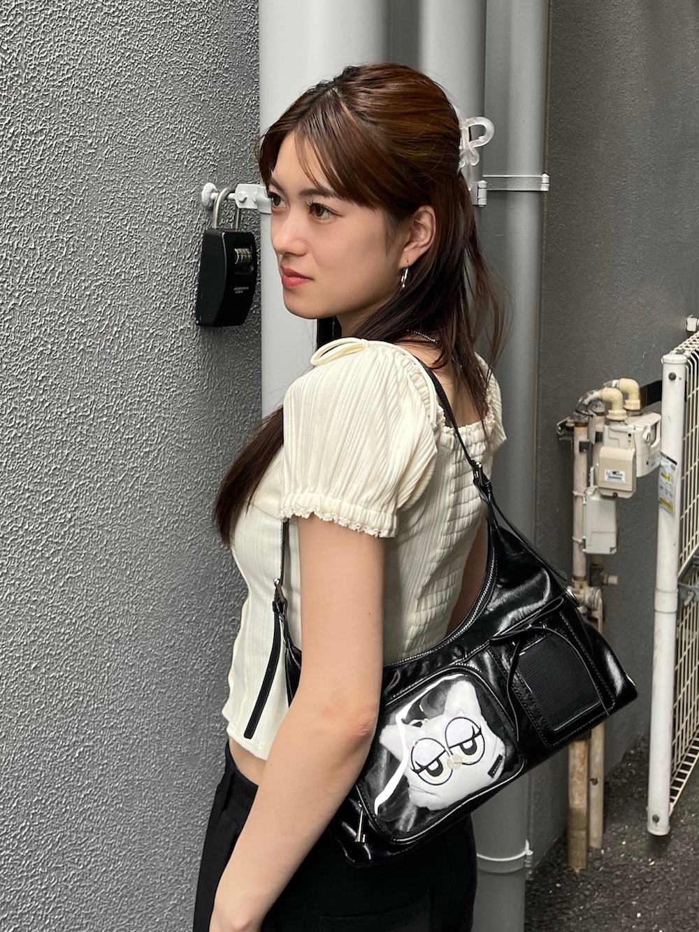 ホワイト系のTシャツ/カットソー、ブラック系のスウェットパンツ、ブラック系のハンドバッグを着用したレディースの夏コーディネートの5枚目の写真