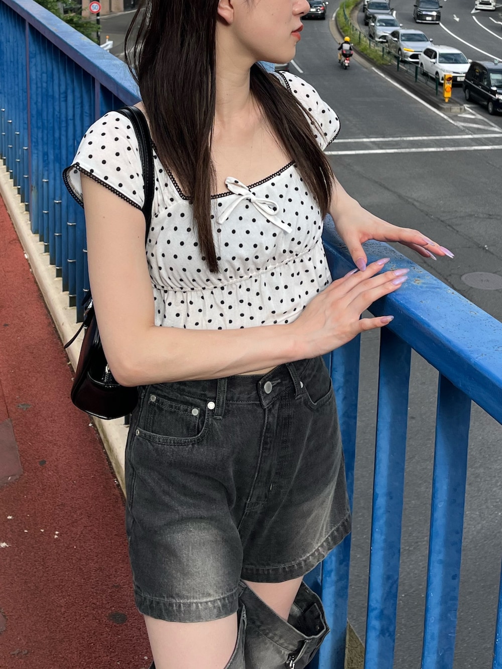 ホワイト系のタンクトップ、ブラック系のデニムパンツ、ブラック系のサンダルを着用したレディースの夏コーディネートの5枚目の写真