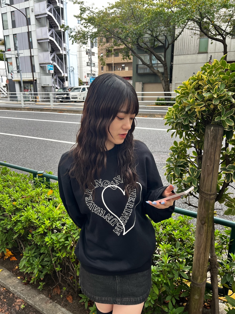 ブラック系のスウェット、ブラック系のスカート、ブラック系のブーツを着用したレディースの秋コーディネートの3枚目の写真