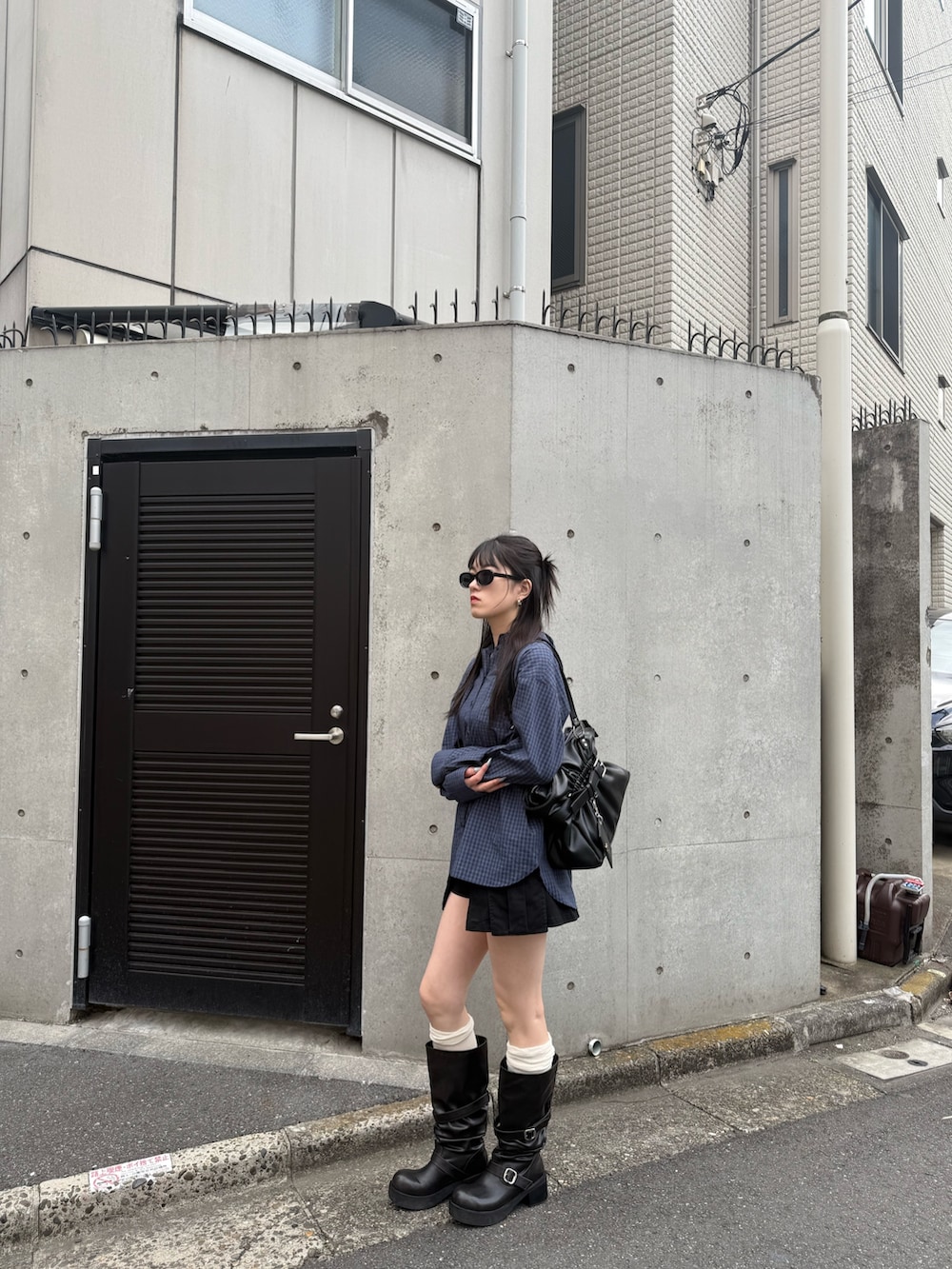 ブラック系のブーツ、ブルー系のシャツ/ブラウス、ブラック系のスカートを着用したレディースの春コーディネートの2枚目の写真