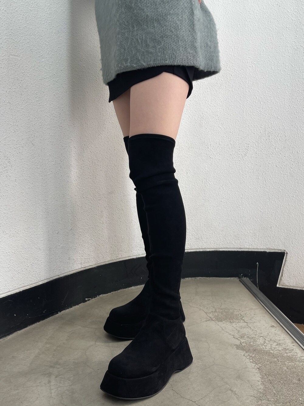 ブラック系のブーツ、ブラック系のスカート、ブルー系のニット/セーターを着用したレディースの冬コーディネートの7枚目の写真