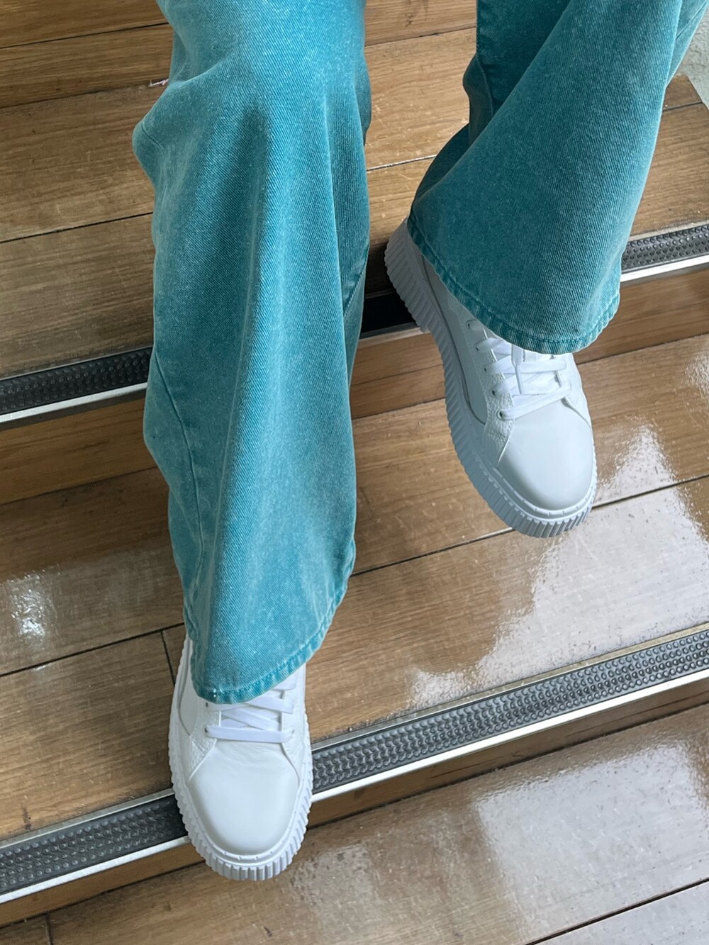 グリーン系のデニムパンツ、ブラック系のTシャツ/カットソー、ホワイト系のスニーカーを着用したレディースの夏コーディネートの7枚目の写真