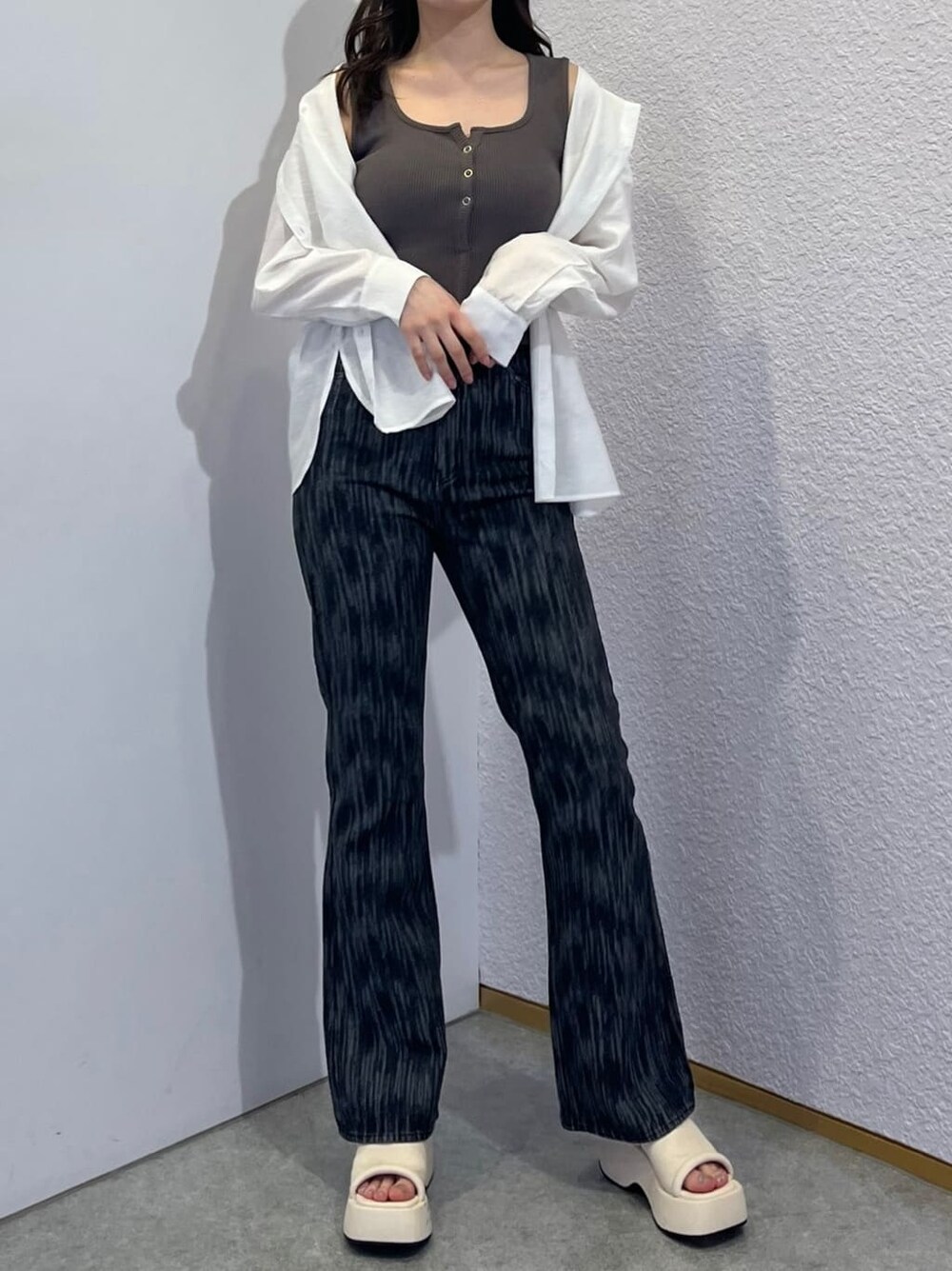 ホワイト系のサンダル、ホワイト系のシャツ/ブラウス、ブラック系のデニムパンツを着用したレディースの夏コーディネートの2枚目の写真