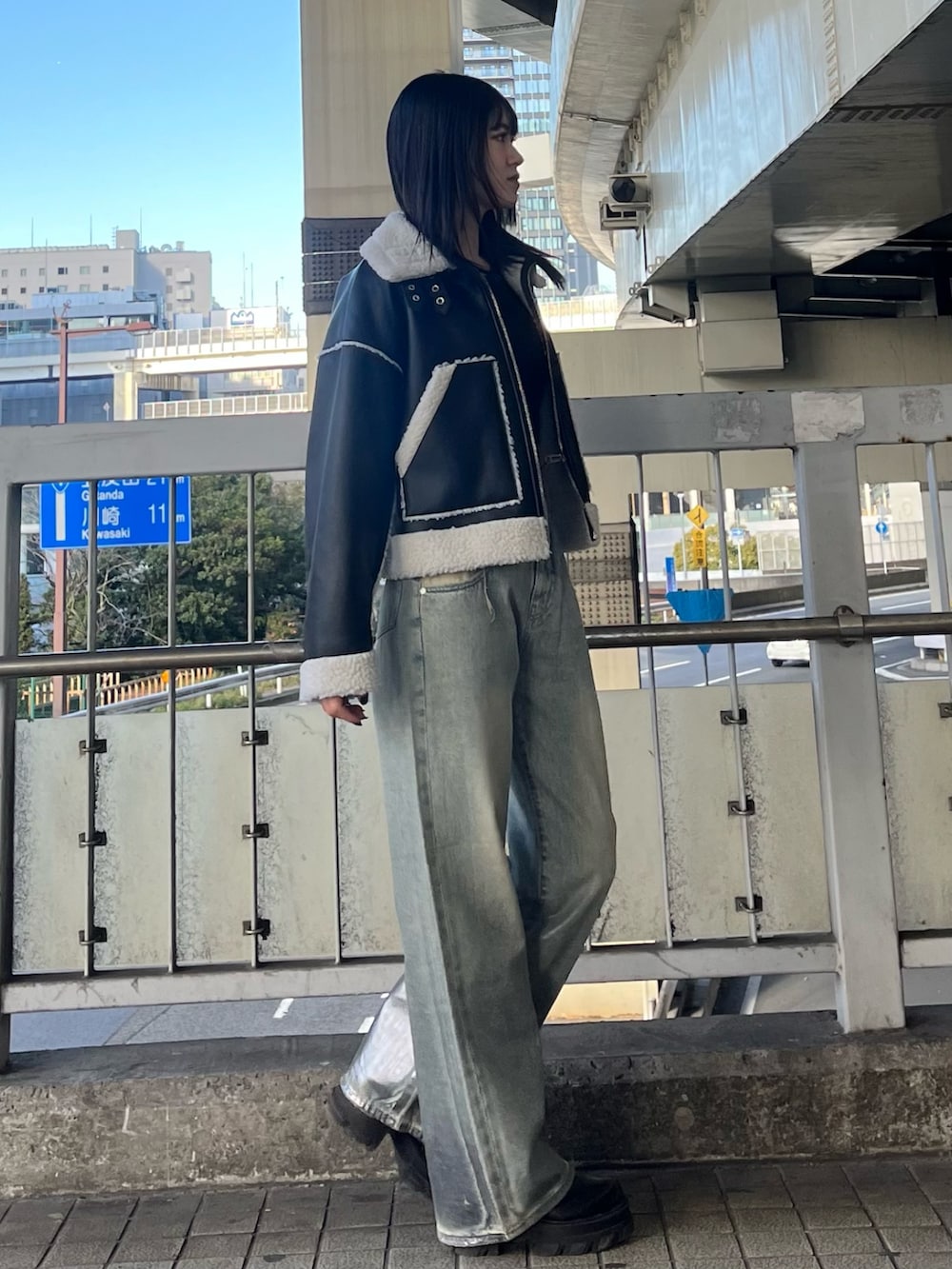 ブルー系のデニムパンツ、ブラック系のニット/セーター、ブラック系のブーツを着用したレディースの冬コーディネートの5枚目の写真