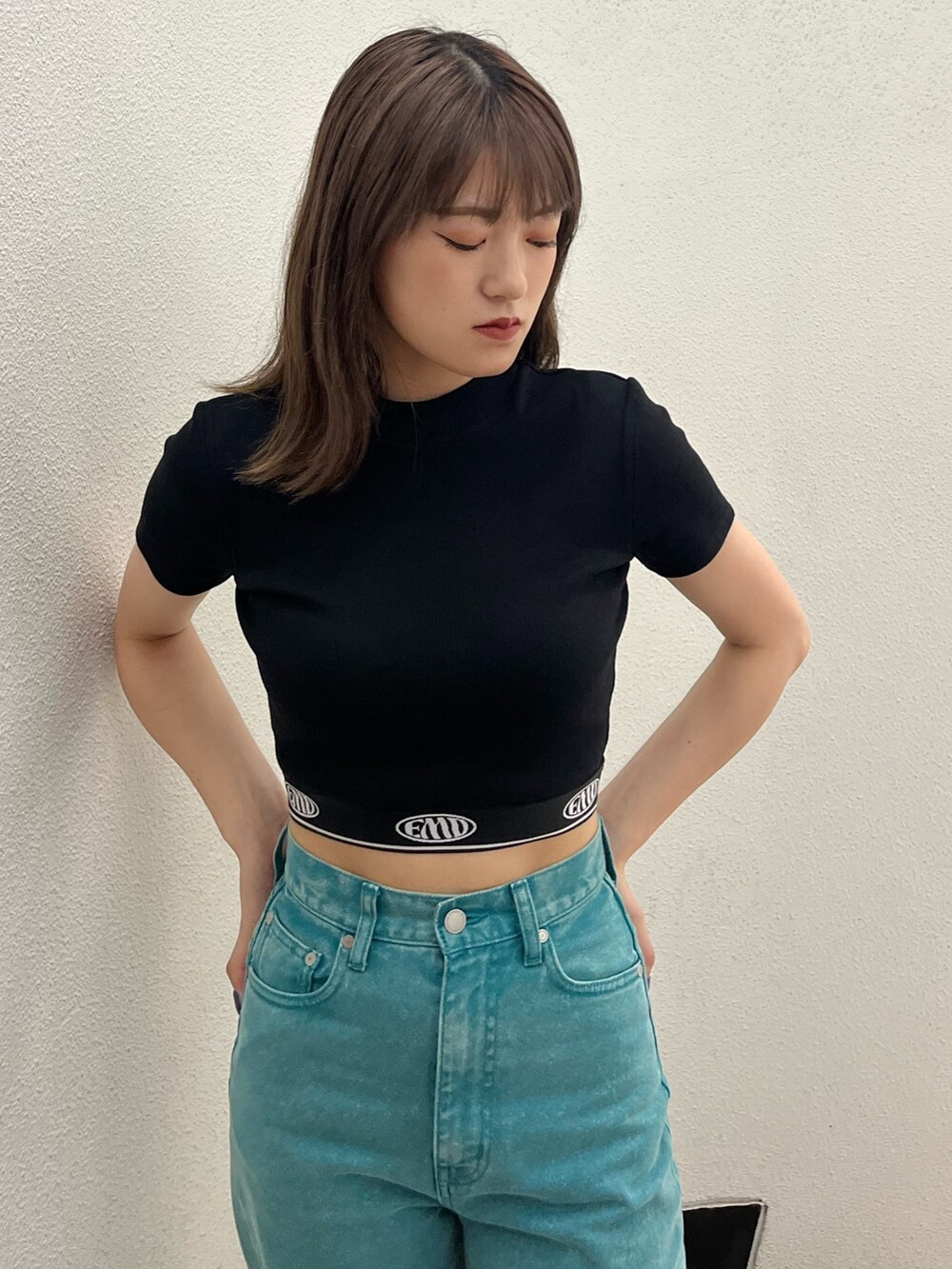 グリーン系のデニムパンツ、ブラック系のTシャツ/カットソー、ホワイト系のスニーカーを着用したレディースの夏コーディネートの5枚目の写真