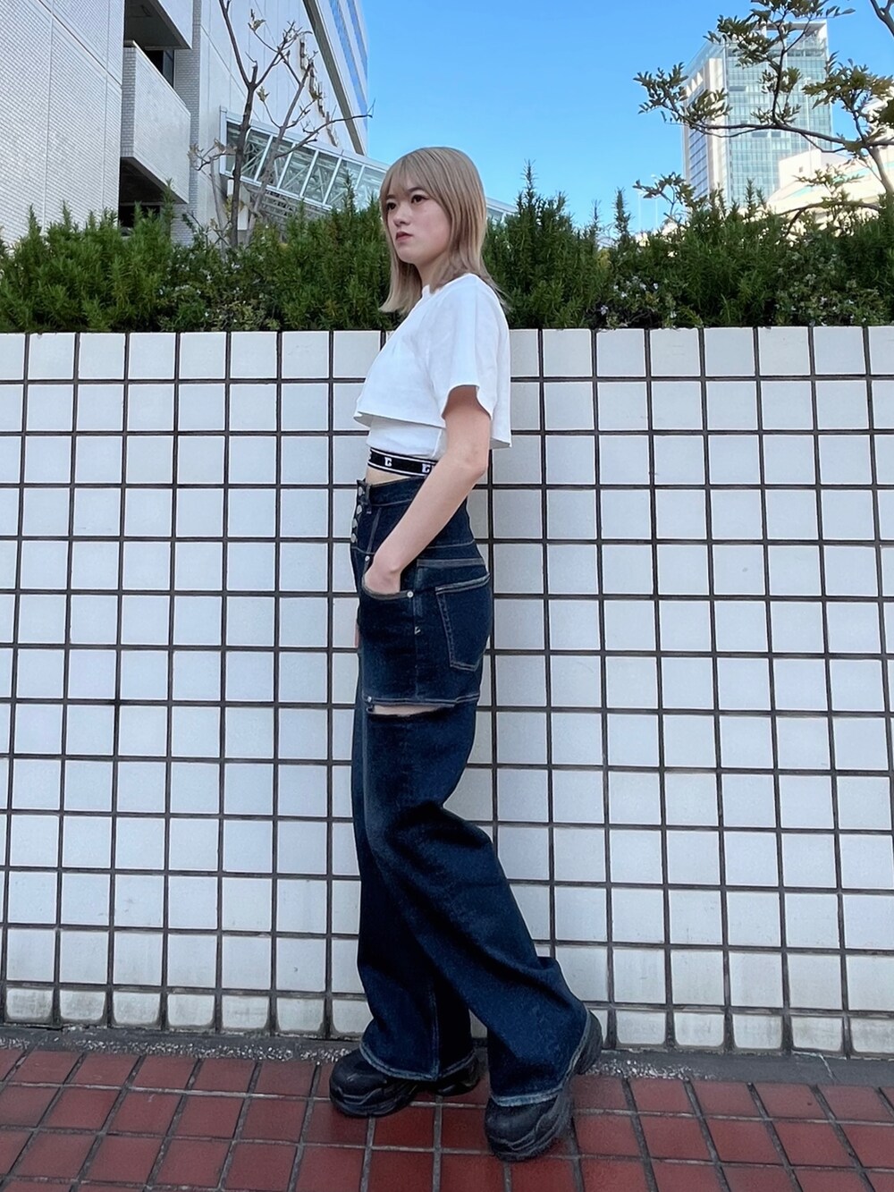 ブラック系のスニーカー、ブルー系のデニムパンツ、ホワイト系のTシャツ/カットソーを着用したレディースの春コーディネートの2枚目の写真