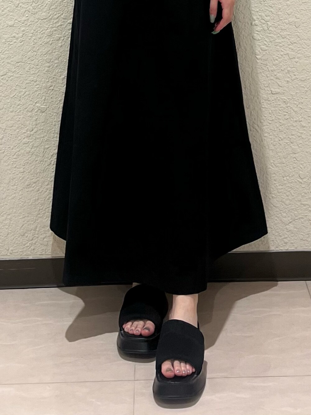 ブラック系のサンダル、ブラック系のワンピースを着用したレディースの夏コーディネートの7枚目の写真