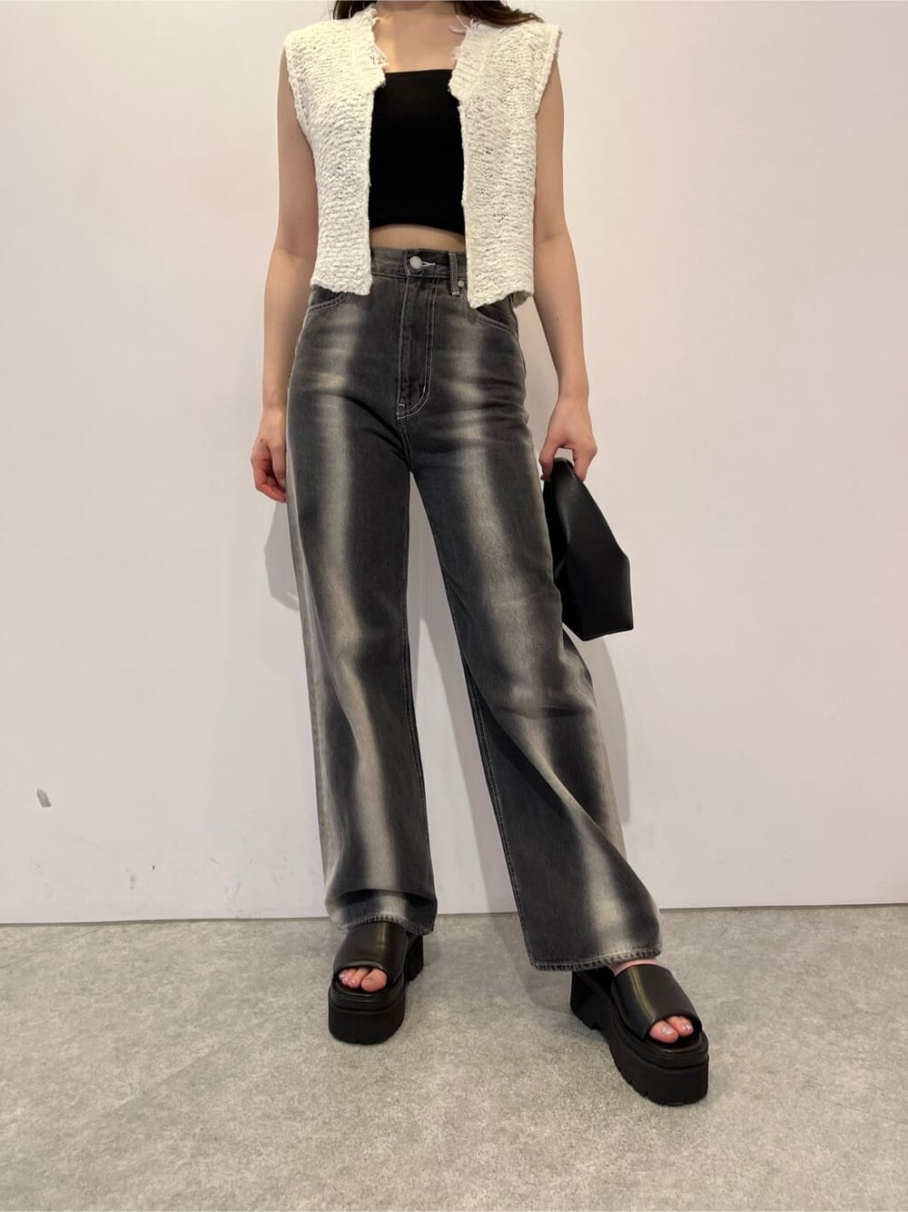 ブラック系のキャミソール、ブラック系のサンダル、ブラック系のデニムパンツを着用したレディースの夏コーディネートの6枚目の写真